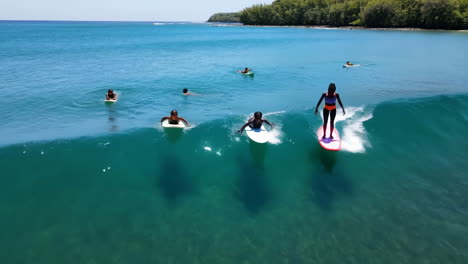 young surfers catching waves in clear tropical waters