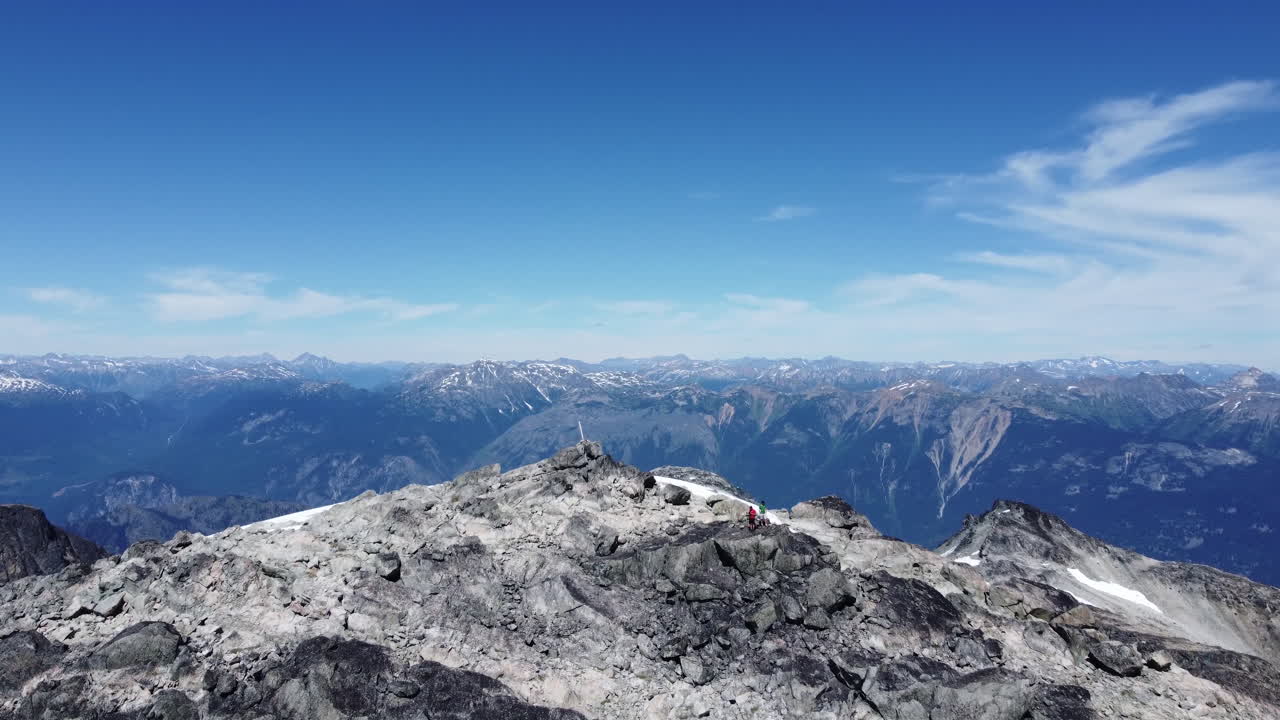 눈과 흐린 푸른 하늘이 있는 광활한 산악 풍경과 캐나다 bc 4k의 태평양 범위에 있는 등산객들의 놀라운 공중 드론 샷