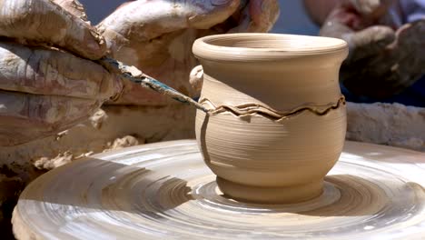 hands of the master potter and vase of clay on the potter's wheel