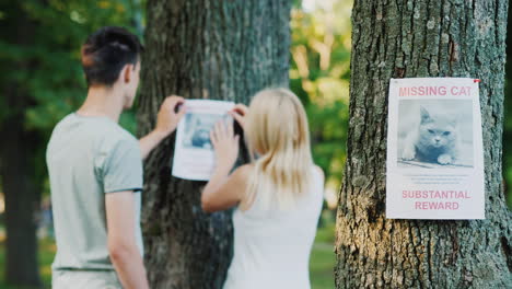 Young-Couple-Putting-Up-Missing-Pet-Banners