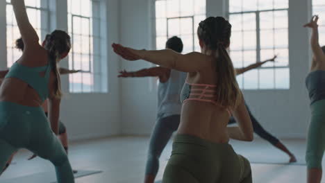 yoga-class-of-healthy-women-practicing-low-lunge-twist-pose-in-fitness-studio-at-sunrise-enjoying-early-morning-exercise