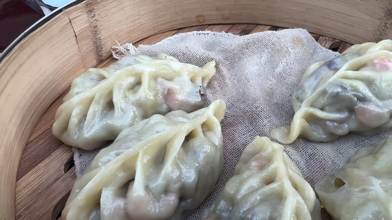 Eating steamed fresh vegetable dumplings with chopsticks