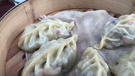 eating steamed fresh vegetable dumplings with chopsticks