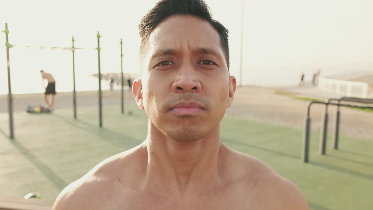 Shirtless man exercising on the beach