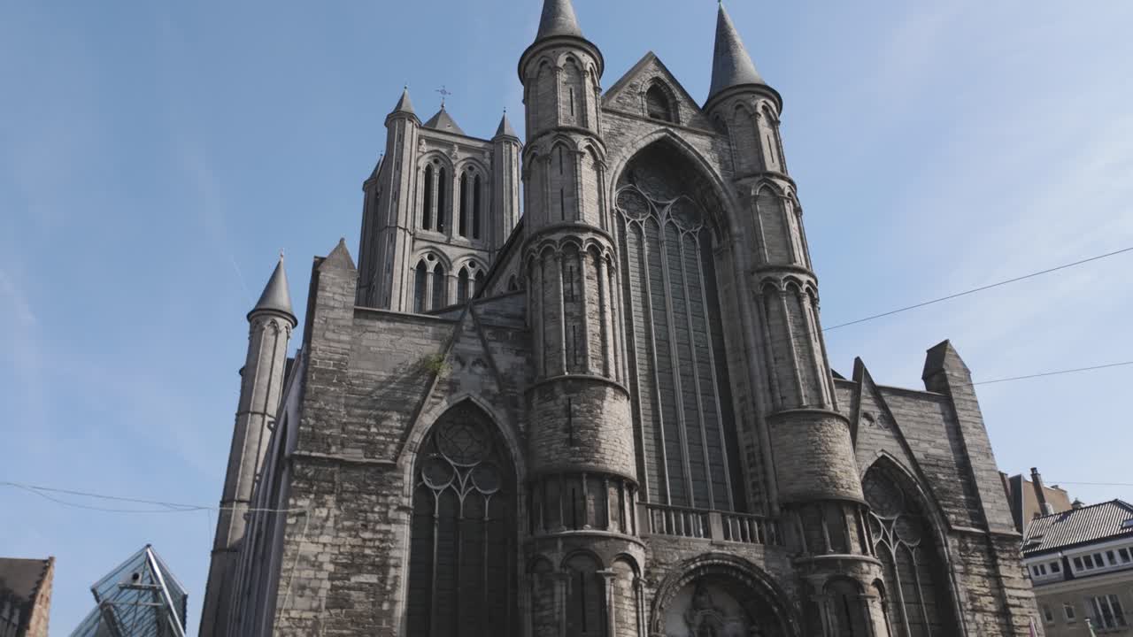 низкий угол зрения церкви святого николая в гент, бельгия, подчеркивая готические архитектурные детали на фоне ясного голубого неба