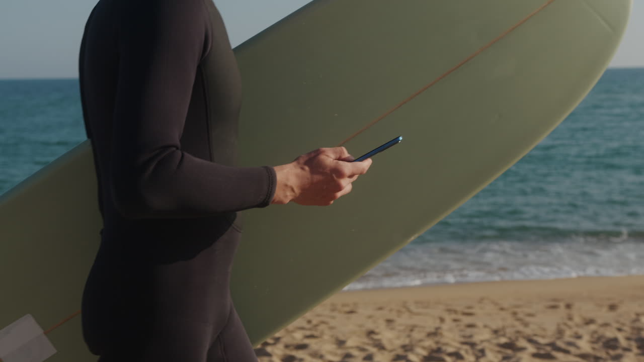 Surfer man walking to the beach at sunset preparing for surfing training and search for waves in Barcelona, spain, water, ocean exercise in sea with board, athletic male holiday or travel in vacation