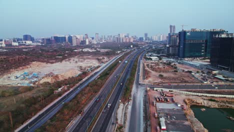 outer ring road with service road and commercial buildings at day time, rising shot, drone shot, 4k.