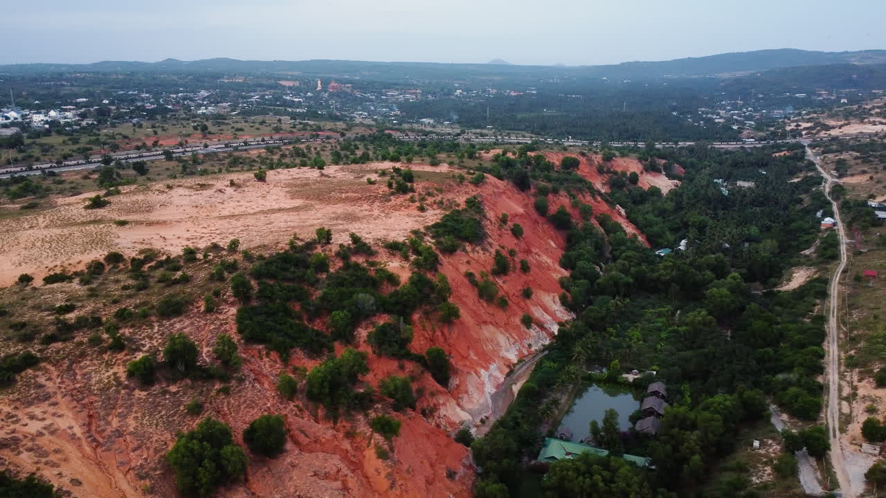 paisaje de dunas de arena roja con vegetación que rodea el arroyo de hadas