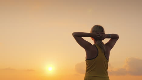 active middle-aged woman looks forward to the sea where the sun rises start a new day and a healthy