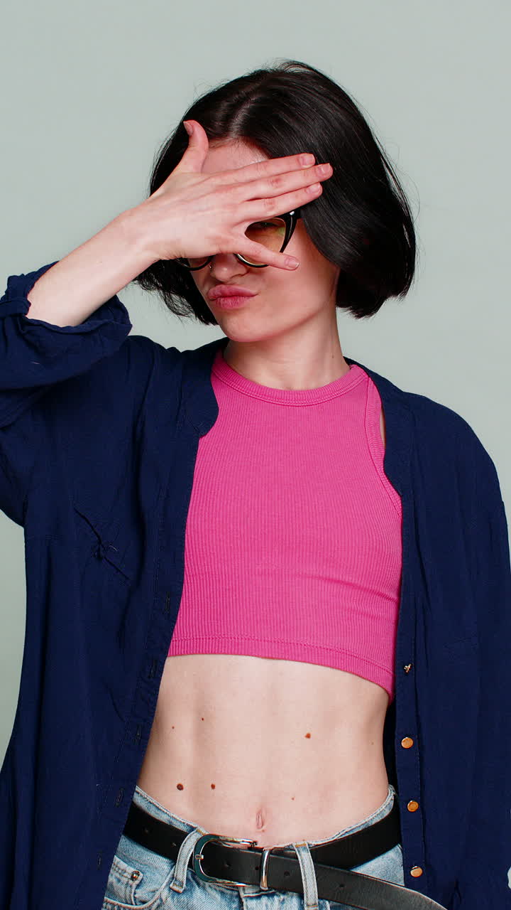 Woman playfully spying through hand shaped like binoculars smiling humorously indicating curiosity