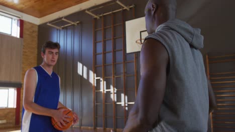 jugador y entrenador de baloncesto caucásico practicando el tiro con la pelota