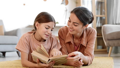 niña leyendo un libro con su mamá en casa.