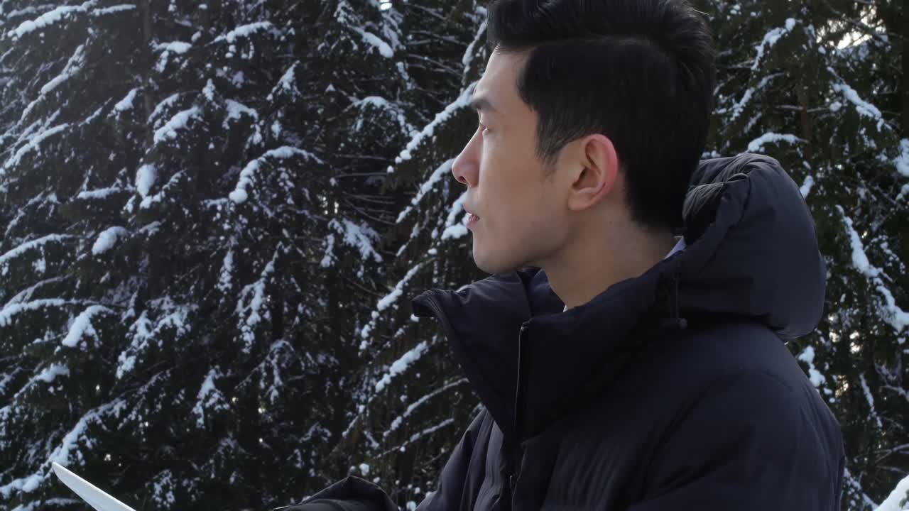 디지털 태블릿 4k를 사용하는 따뜻한 옷을 입은 남자