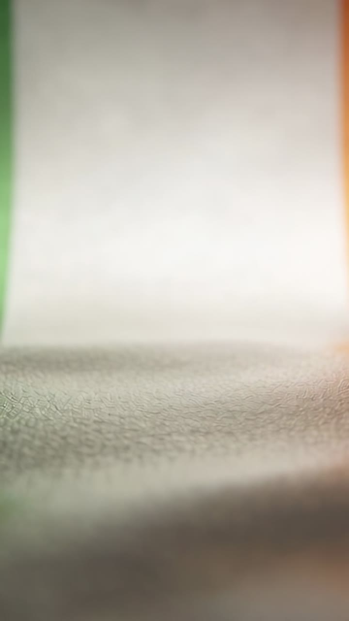 Vertical video: Camera pulling back, revealing green white cream orange fabric panel on tabletop