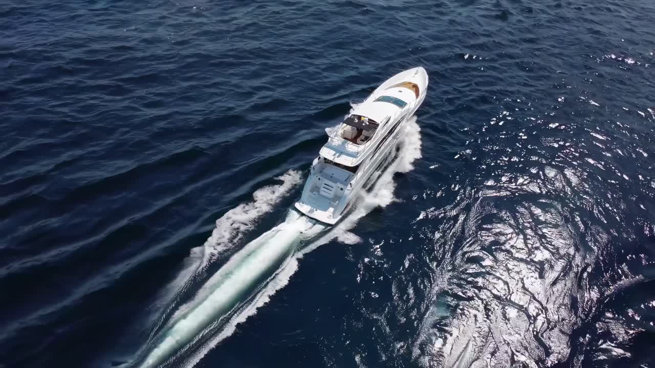 Aerial video captures a luxury yacht cruising through deep blue waters, showcasing elegance