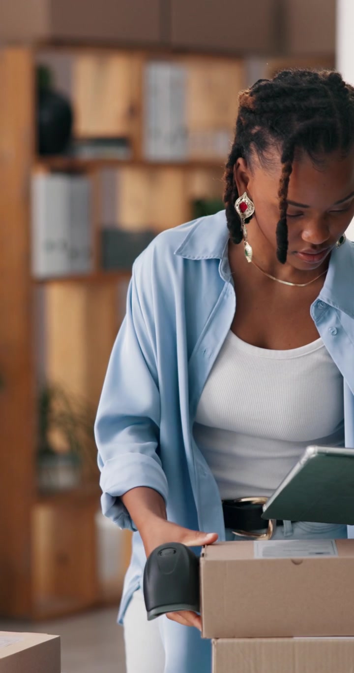 Young Woman Scanning Packages in a Warehouse Office