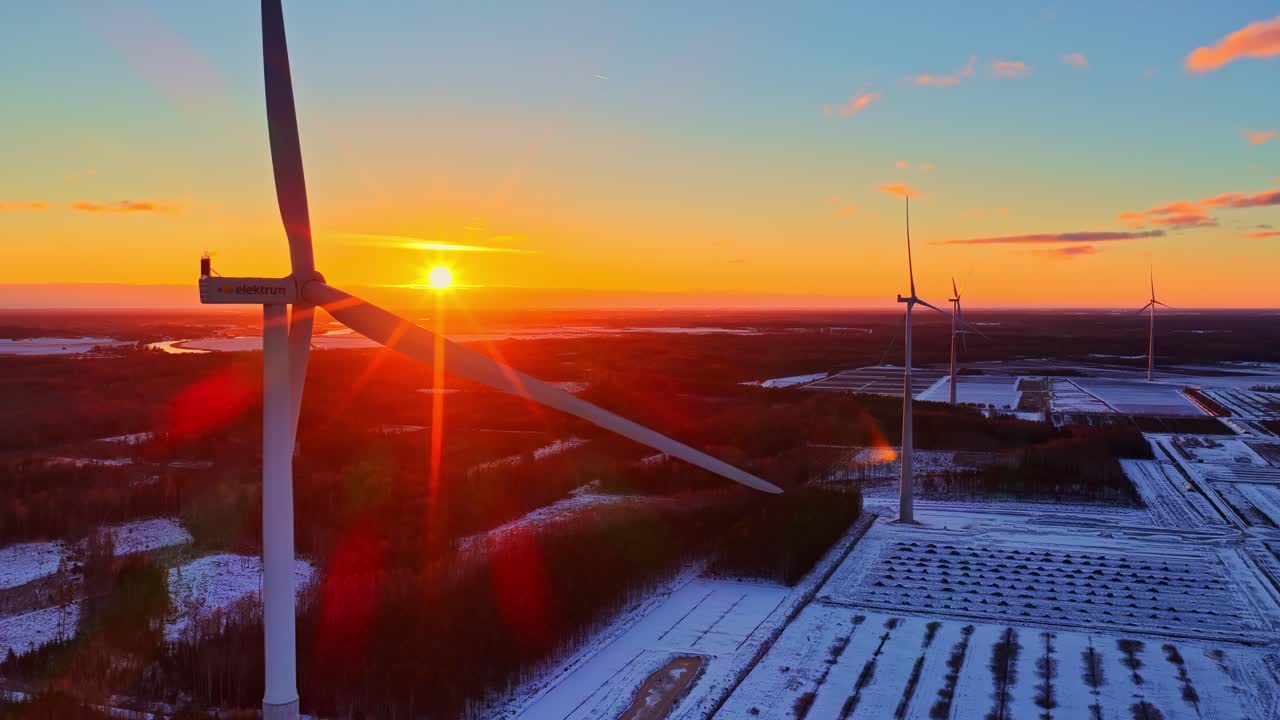 Vedvarende vindmølle drejer langsomt ved solopgang. Luftfoto