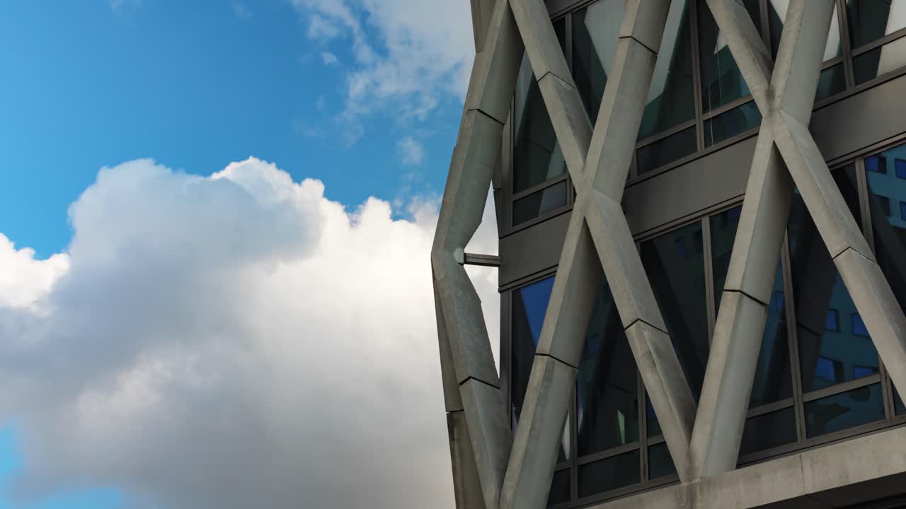 Diagrid tower corner with drifting clouds in timelapse expressing the passage of time