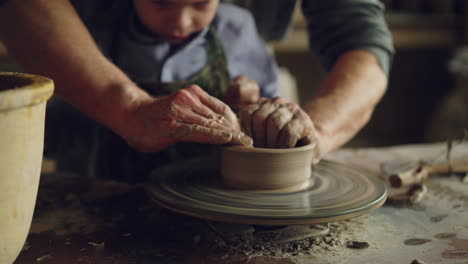 father and son learning pottery