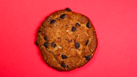 una galleta de chocolate en primer plano, una foto macro, girando lentamente sobre un fondo rojo giratorio.
