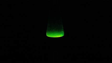lámpara de lava verde brillando en la oscuridad
