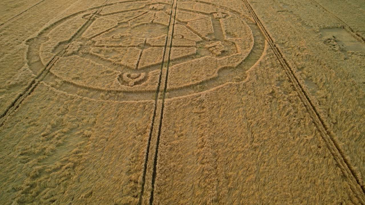 Wiltshire wheat field countryside crop circle molecular pattern aerial view rural scene low forward tilt down at sunset