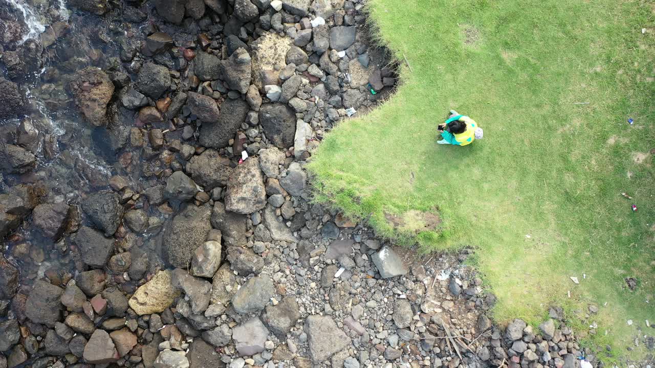 persona que observa la contaminación costera