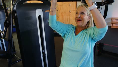 mujer mayor haciendo ejercicio en la máquina de prensa de pecho 4k