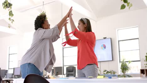 Happy-diverse-business-female-colleagues-high-fiving-in-office,-slow-motion