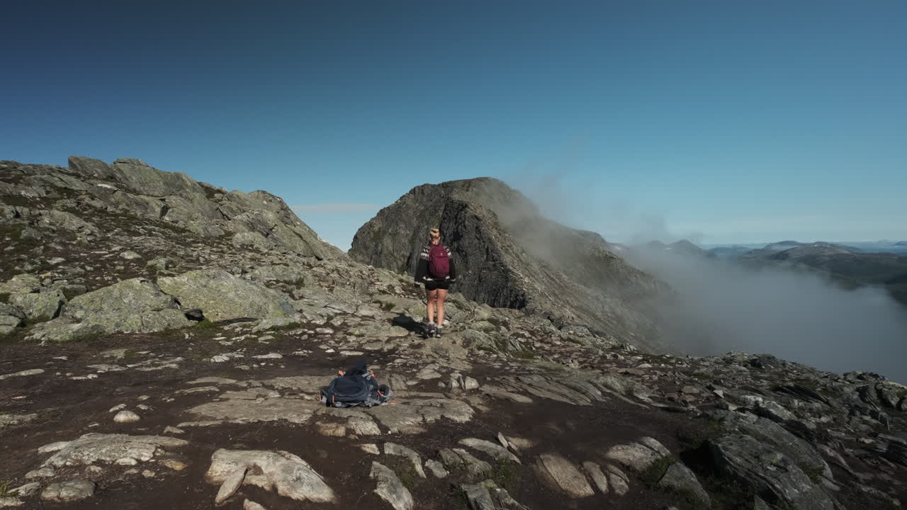 Backpacker Woman Hiking On Romsdalseggen Ridge In Norway - wide shot