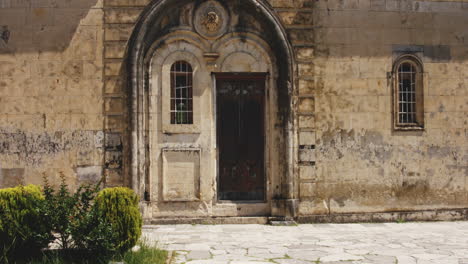 Patio-De-Piedra-Pavimentada-Y-Puerta-De-Pared-De-Madera-Cerrada,-Monasterio-De-Motsameta