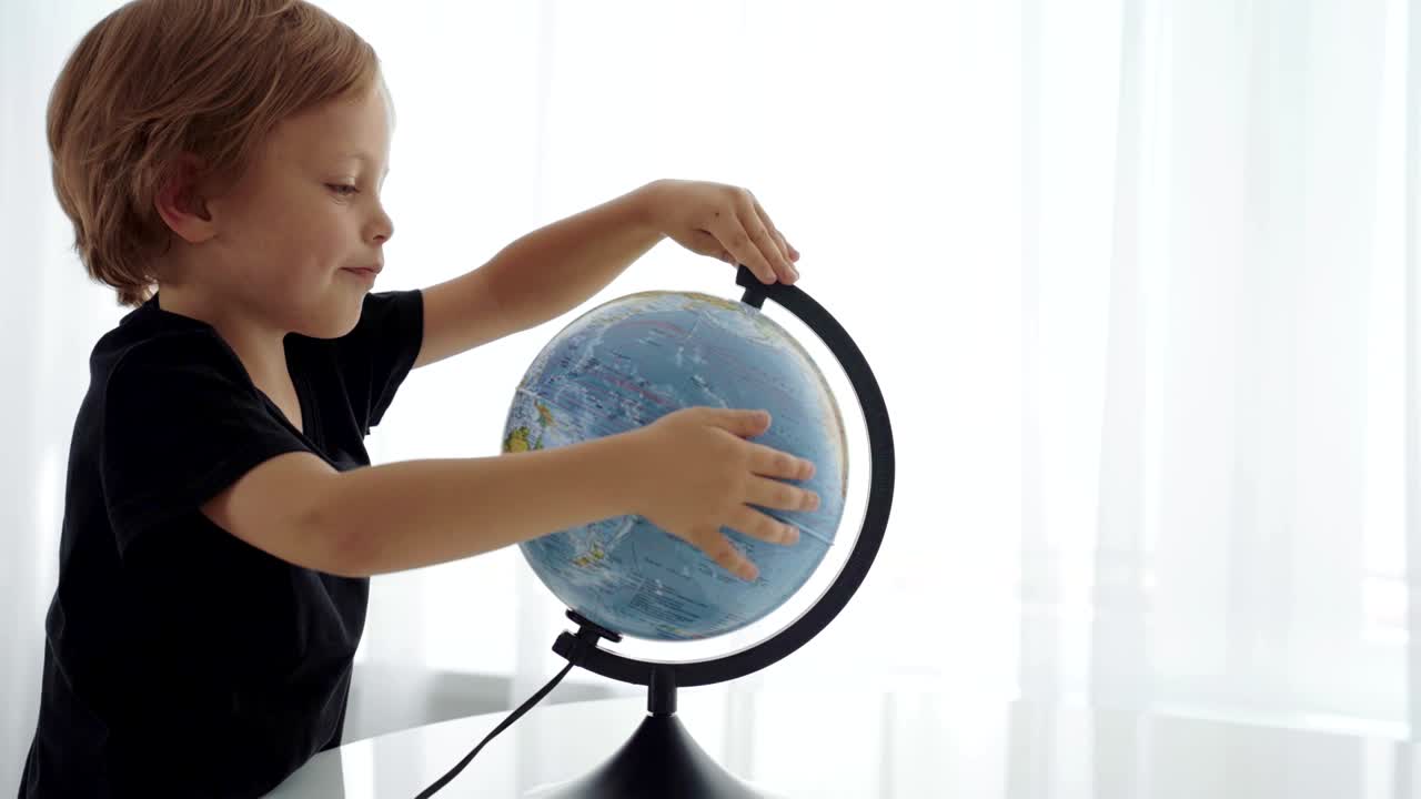 chicos caucásicos lindos girando el globo y soñando con viajar.