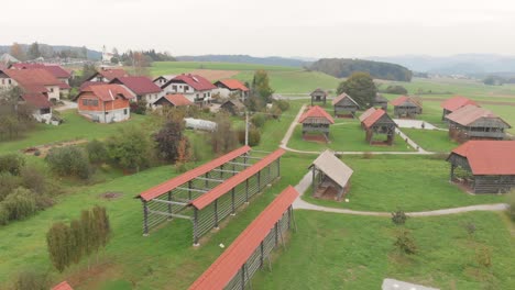 Una-Vista-De-Drones-De-Una-Granja-Con-Cabañas-Y-Viviendo-En-Un-Pueblo-Con-Un-Exuberante-Valle-De-Campo-Verde