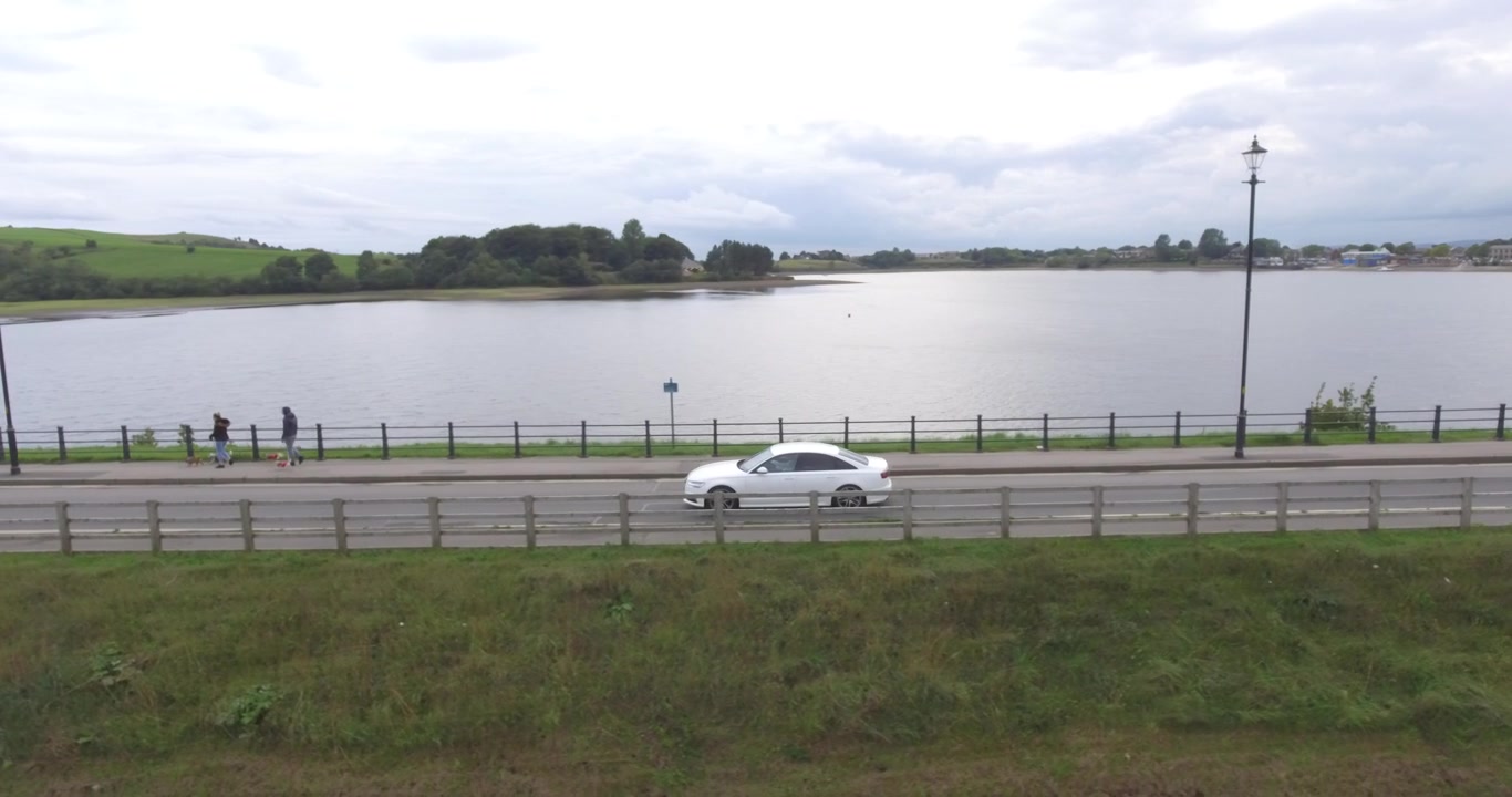Carro dirigindo ao longo do lago no campo na Inglaterra.
