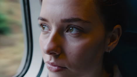 young woman looking out train window