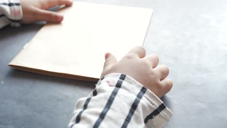 vista trasera de la mano del niño sosteniendo un papel