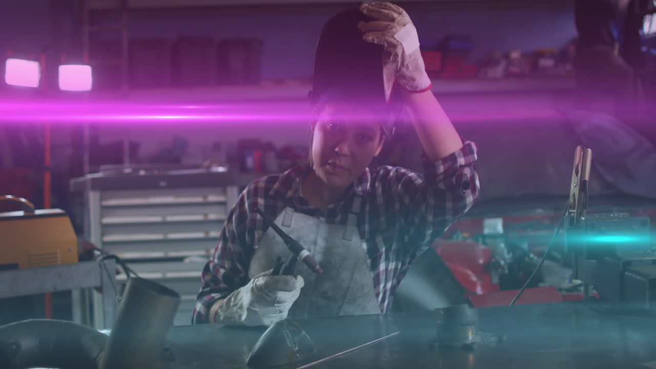 animación de luz brillante sobre una mujer biracial que trabaja en un taller de automóviles