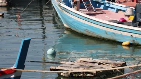 a boat approaches and docks at a wooden pier.