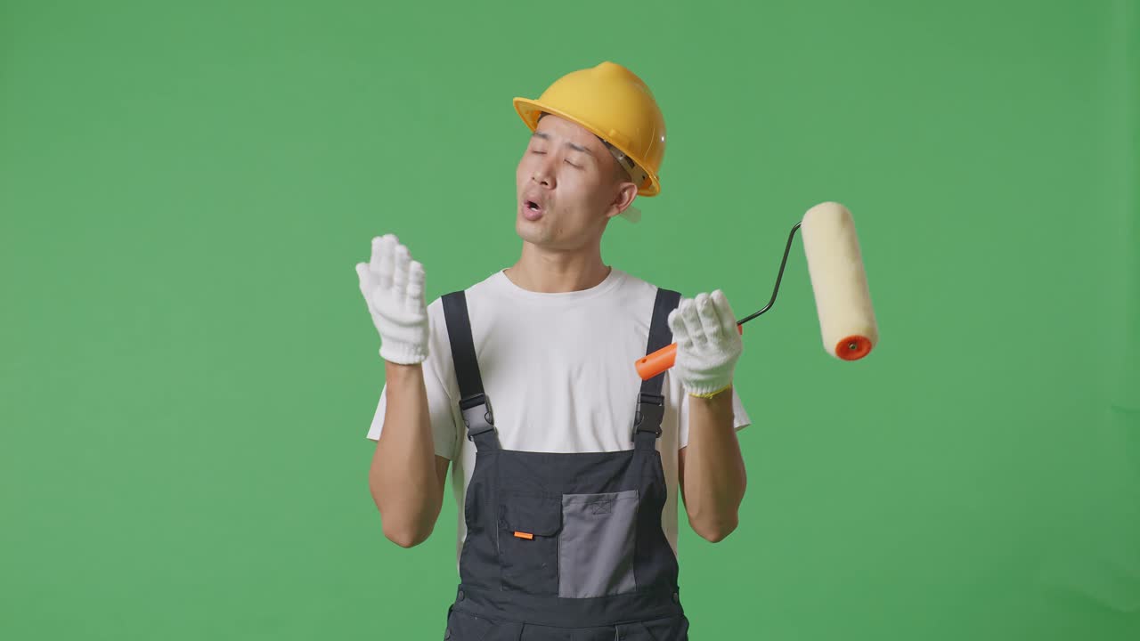 Wondering Asian Man Painter Wearing Safety Helmet Saying Why And Standing Doubtfully In The Green Screen Background Studio