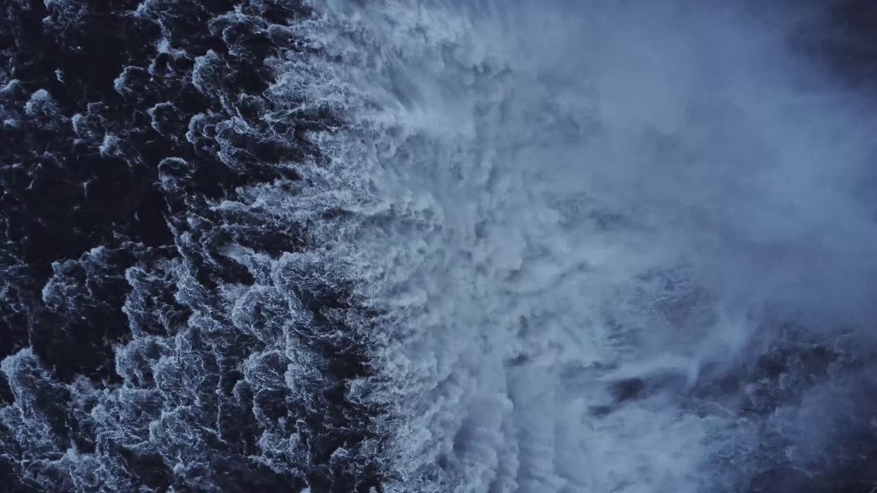Waterfall on snowy cliff in winter