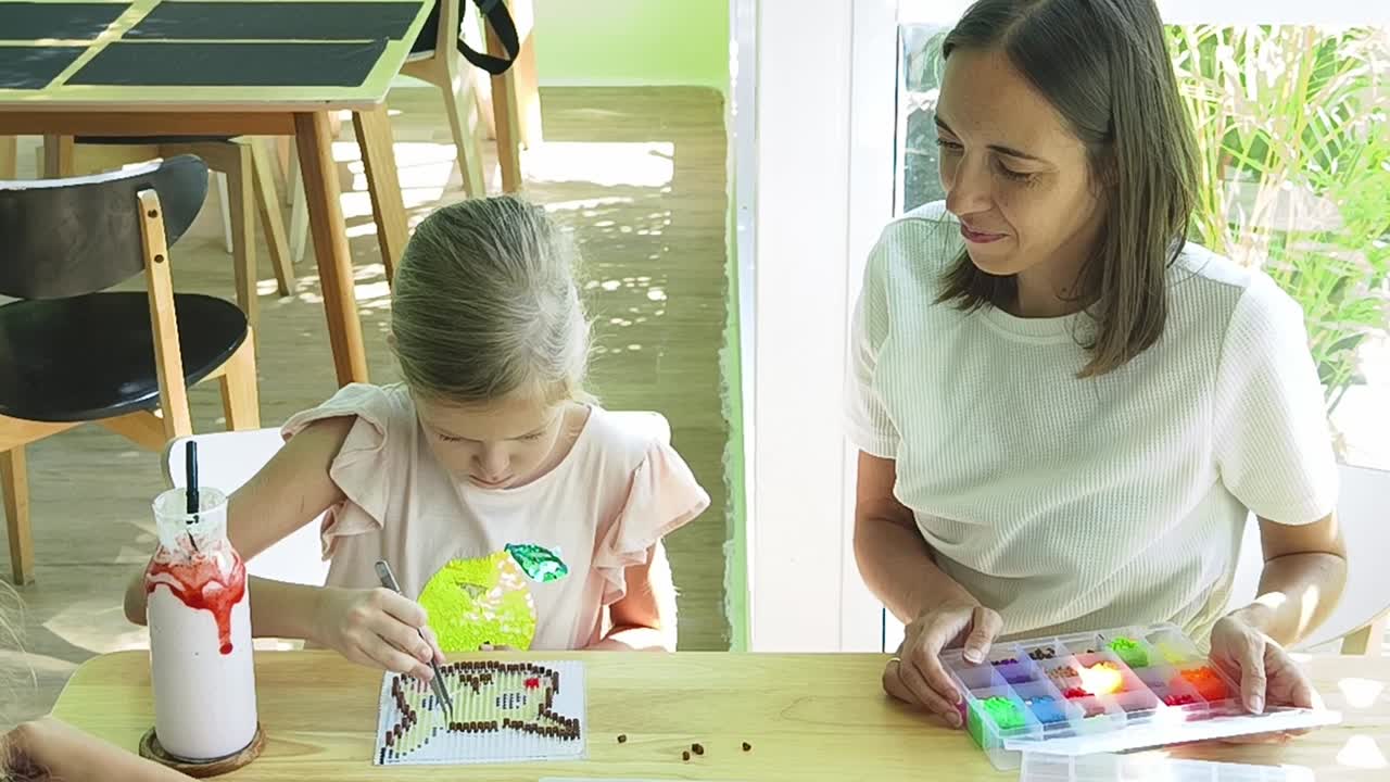 madre e hija beading juntos en un café