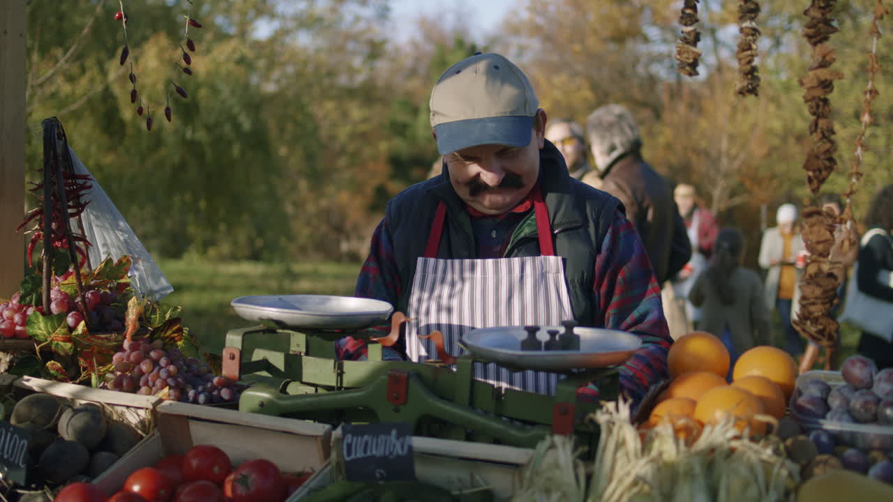 Senior Farmer Gives Paper Eco Bag with Goods Senior Farmer Seller Gives Paper Eco Bag with Fruits or Vegetables to the Woman Outdoors Shopping at Local Farmers Market on Weekend Vegetarian Organic and Healthy Food Agriculture