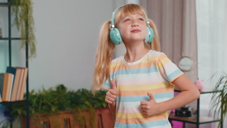 happy teen girl in wireless headphones relaxing sitting on sofa at home listening favorite music