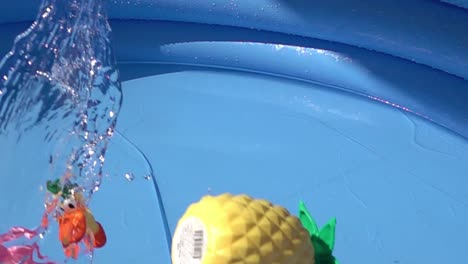 toys falling on a pool in slow motion