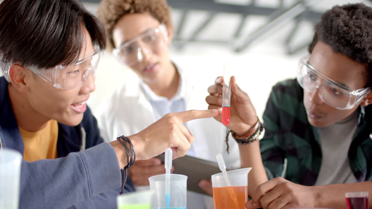 In high school, teenagers conducting science experiment with test tubes and beakers