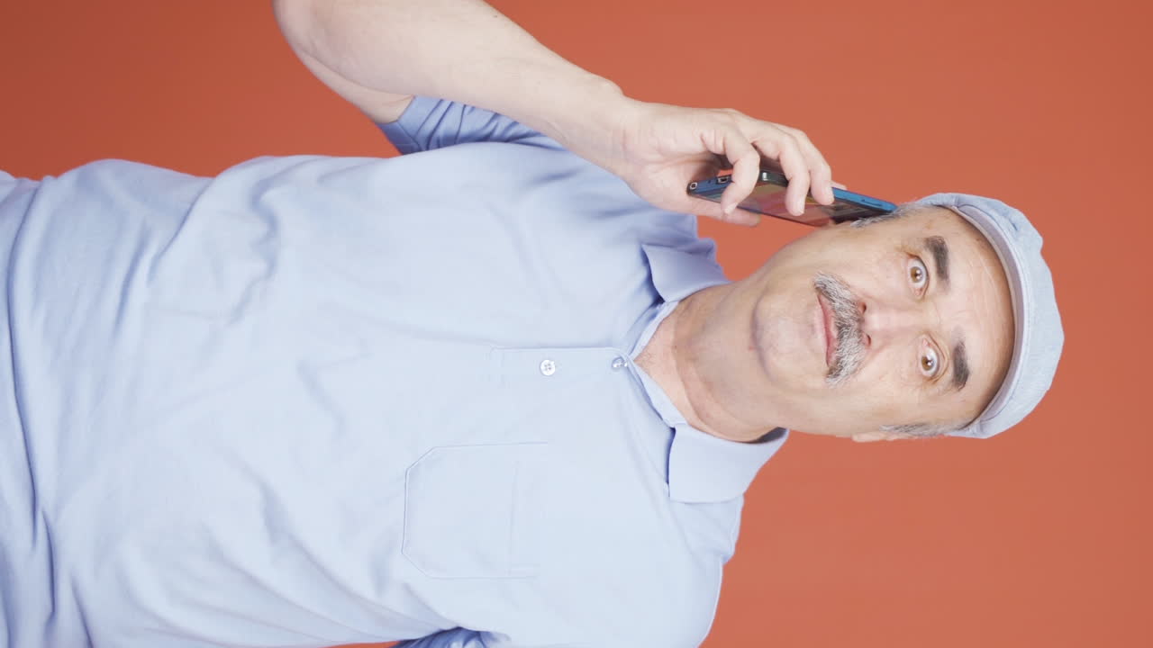 Vertical video of Angry old man talking on the phone.