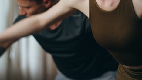 partners doing fitness exercises with dumbbells at home close up. family workout