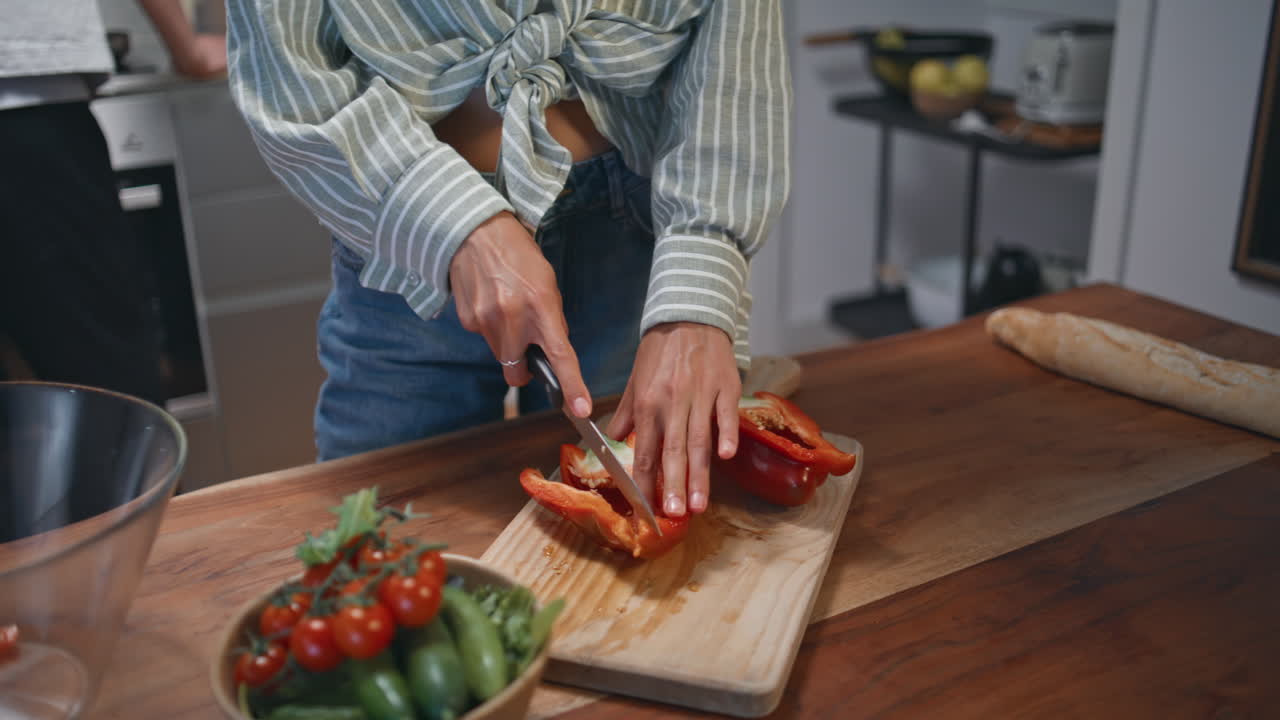 Woman cutting bell pepper at home closeup. Wife preparing vegetarian dinner