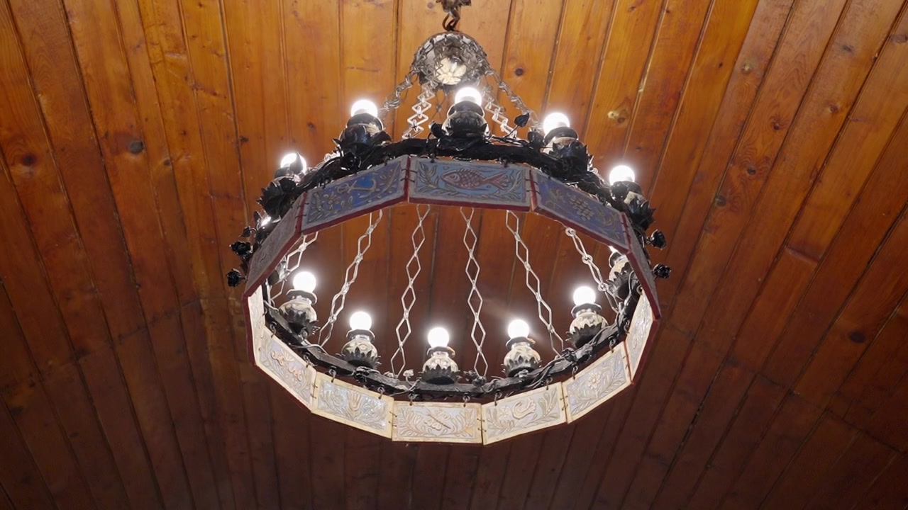 Ein Kronleuchter an einer Holzpaneeldecke