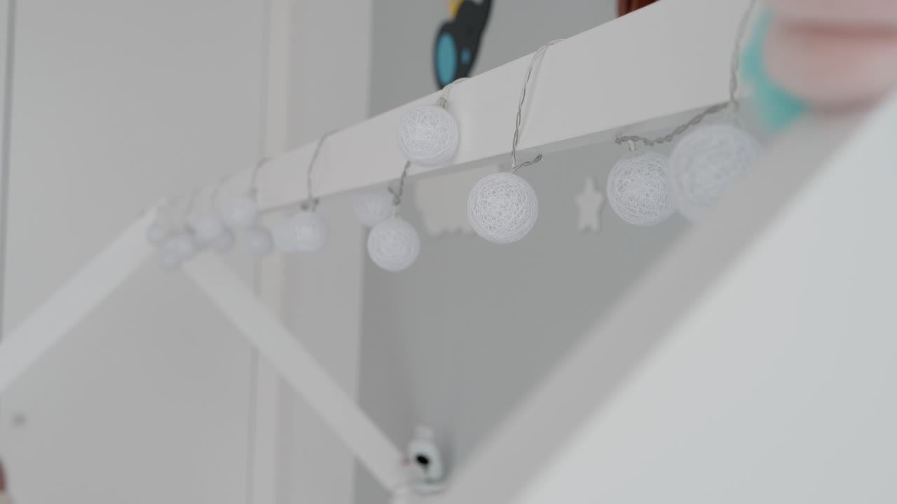 delicate round lights on wire hanging across a white indoor frame